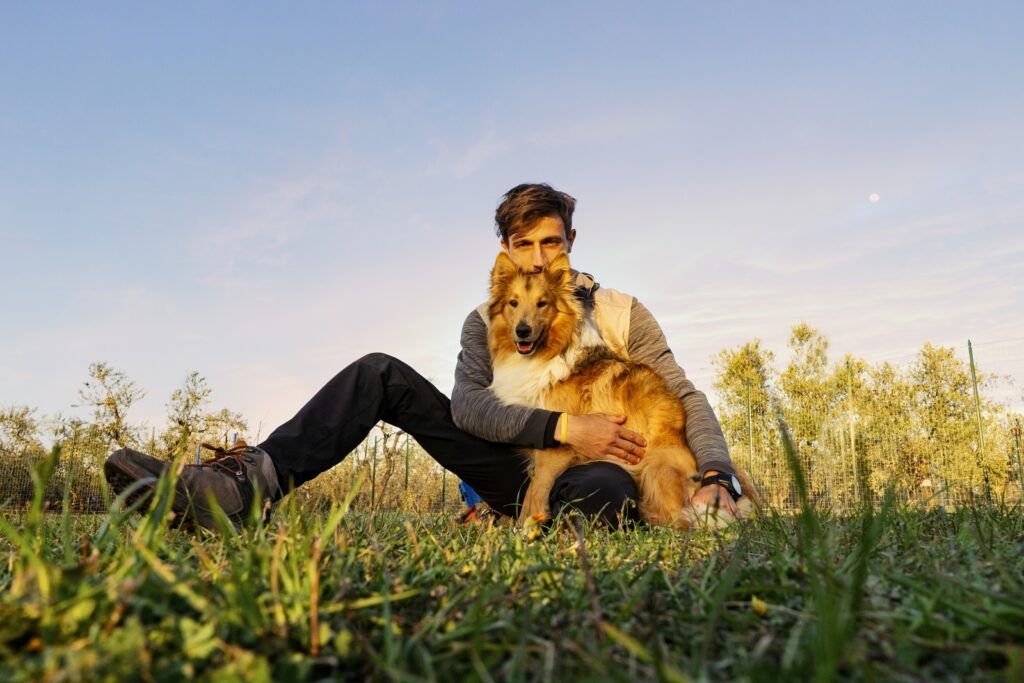 Sirio, cucciolo di Collie, e Ivo, addestratore cinofilo. Sirio è in braccio a Ivo in un prato erboso. 
Posso uscire con il mio cucciolo prima dell'ultimo vaccino? Rispondiamo alla domanda!